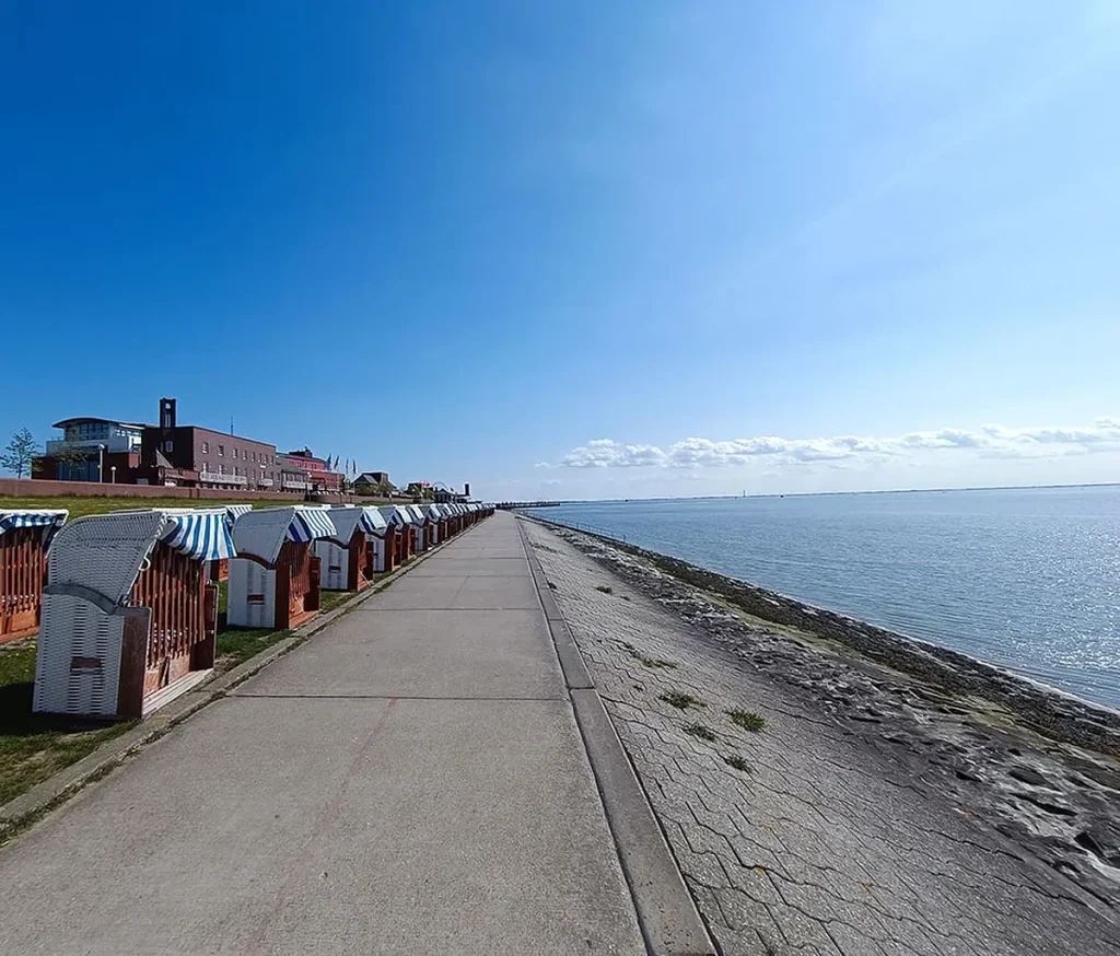 Der Südstrand in Wilhelmshaven im Sommer bei sonnigen Wetter mit Strandkörben und Promenade im Hintergrund